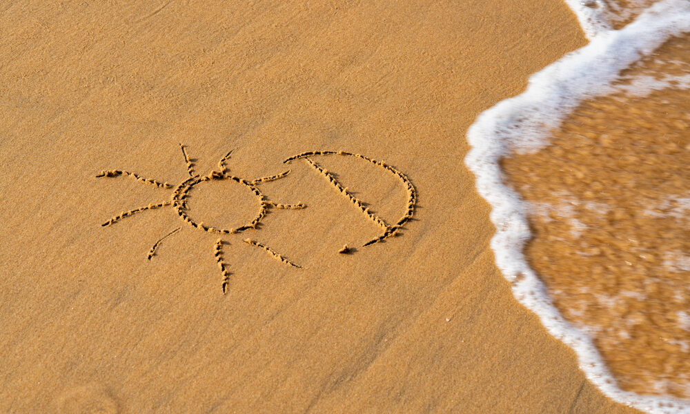 imagen de un sol y la letra d dibujado en la arena haciendo referencia a la vitamina d